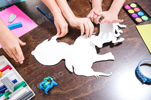 Preview: Cropped shot of children making animals from white paper