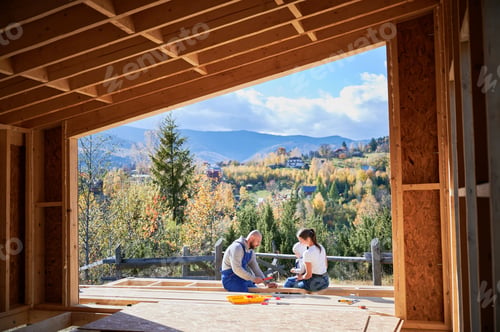 Preview: Father, mother and son building wooden frame house.