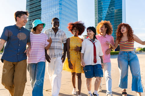 Preview: Multiethnic group of young friends meeting and having fun outdoors