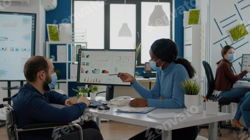 Preview: Invalid manager with face mask explaning to black employee financial evolution