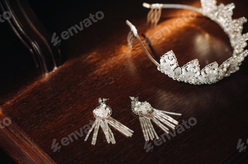 Vista previa: Wedding crown for the bride and earrings lie on the trellis