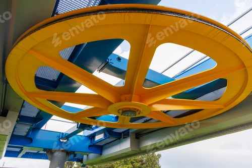Preview: Wheel in a mechanism on a lift in a mountain forest against a cloudy sky