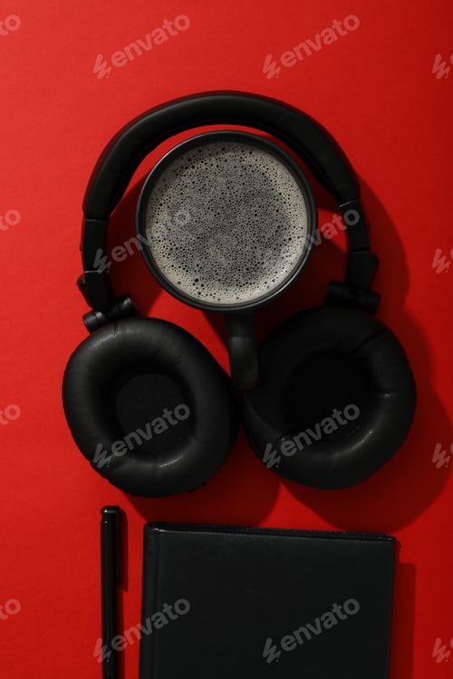 Preview: Black cup of tea with headphones on a red background