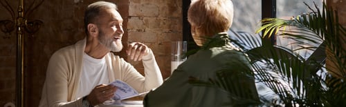 Preview: Mature couple sharing laughter and romance during a cozy lunch in a charming restaurant