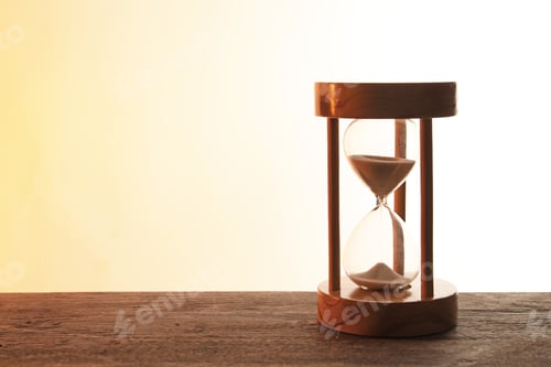 Preview: Hourglass with flowing sand on table against light background. Time management