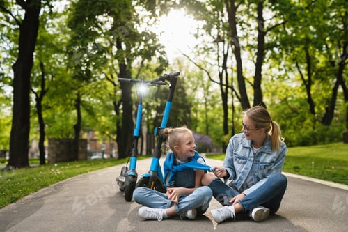 Preview: Mother and daughter sitting on a road after electric scooters ride