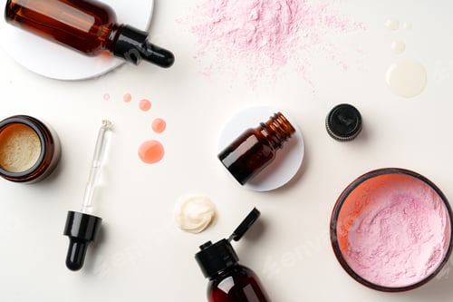 Preview: Assorted Skincare Products and Powder Spilled on a White Background