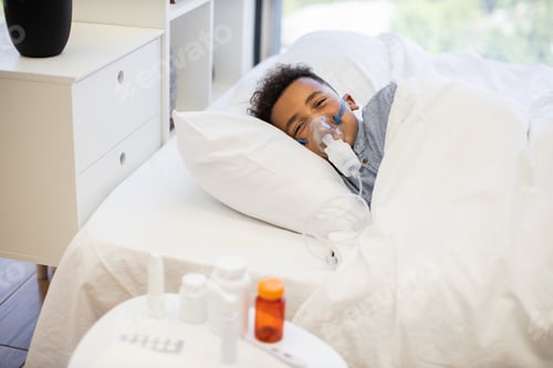 Preview: Young boy using nebulizer for respiratory treatment at home