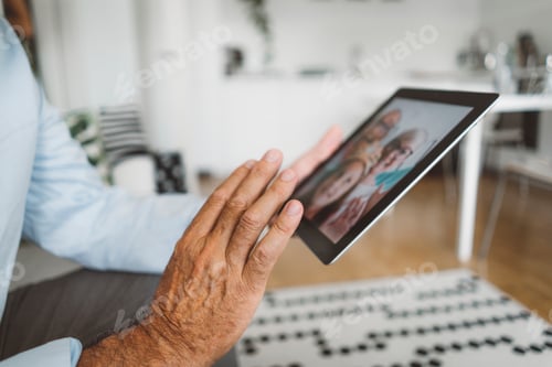Preview: Senior man waving goodby to his family over video call