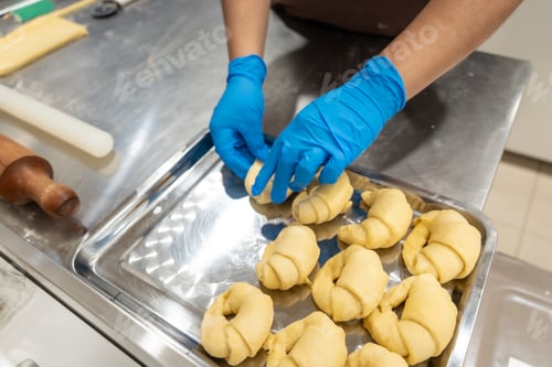 Preview: Chef hands preparing raw croissant dough on tray