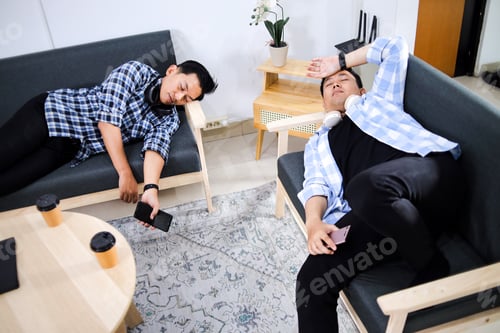 Preview: Exhausted Two Asian Employees Sleeping On Couch After Overworked During Break Time