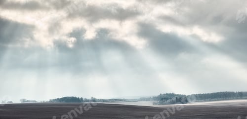 Preview: Sunbeams breaking through the cclouds over a remote landscape