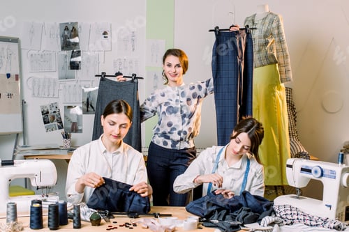Preview: Young smiling fashion designer posing with handmade pants