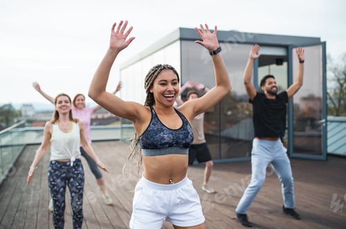 Preview: Group of young people doing exercise outdoors on terrace, sport and healthy lifestyle concept
