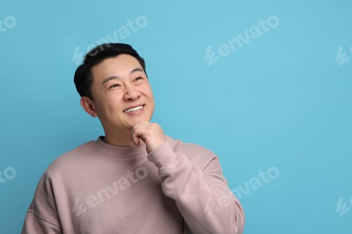 Preview: Portrait of happy man on light blue background. Space for text