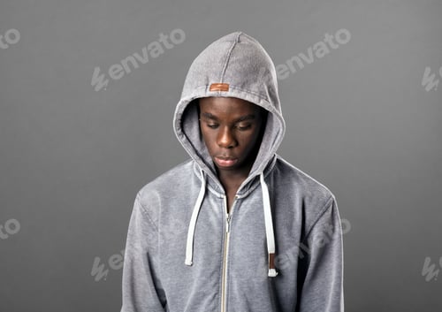 Preview: Young Black man wearing a grey hoodie looking down