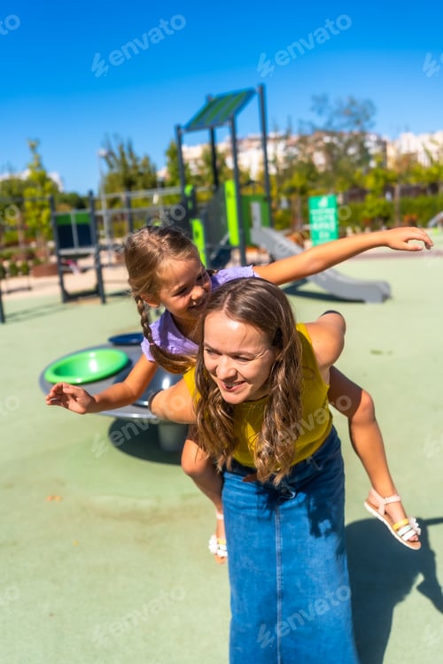 Preview: Mother and daughter having fun playing piggyback ride
