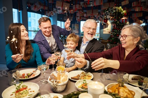 Preview: Smiling family celebrating New Year in restaurant clinking champagne glasses