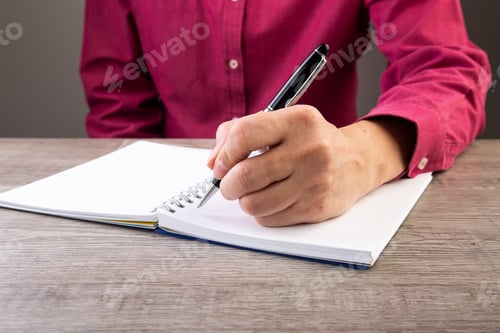 Preview: man left hand writing on paper book ,on table shot