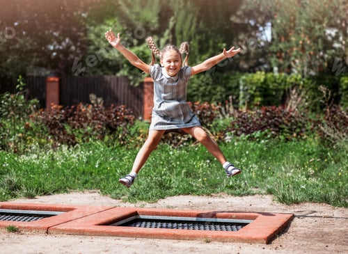 Preview: Little girl is jumping on trampoline in a park.