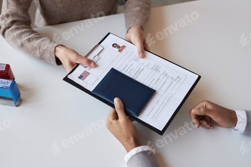 Preview: Above angle of filled form for visa request and passport being passed by man