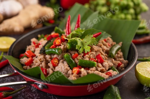 Preview: Stir-fried pork basil on banana leaves in a frying pan.