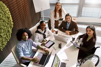 Preview: Diverse business team analyzing charts during office meeting from top view