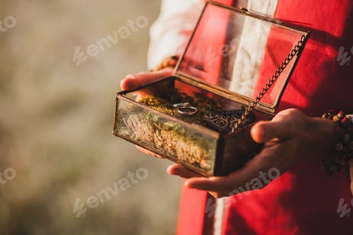 Preview: Priest holding in hands handmade vintage glass box with wedding rings on holy ceremony