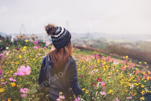 Preview: Young woman traveler walking in the flower field