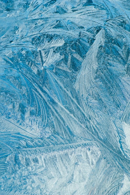 Preview: Winter frosty patterns on glass. Christmas festive background. Ice crystals on window.