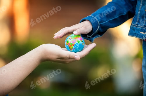 Preview: man giving little girl globe on hand