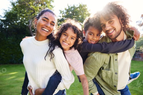 Vista previa: Portrait of family in garden smiling towards camera