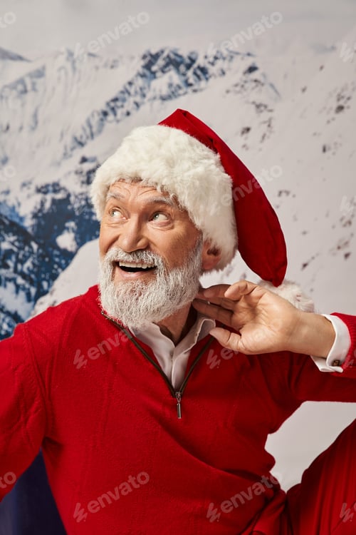 Preview: portrait of cheerful man in Santa costume with hand near neck looking away, winter concept