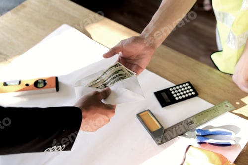 Preview: Top view of owner hand giving money to employee or hired person for his wage or salary over table.