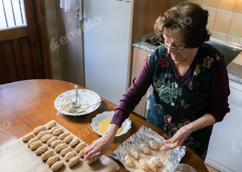 Preview: Aged woman preparing lots of handmade croquettes at home