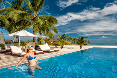 Preview: Woman with hat at beach pool in Maldives