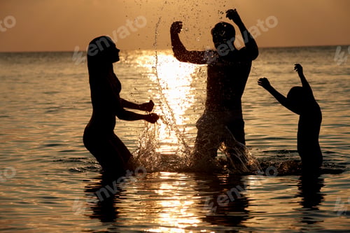 Preview: Silhouette Of Family Having Fun In Sea On Beach Holiday