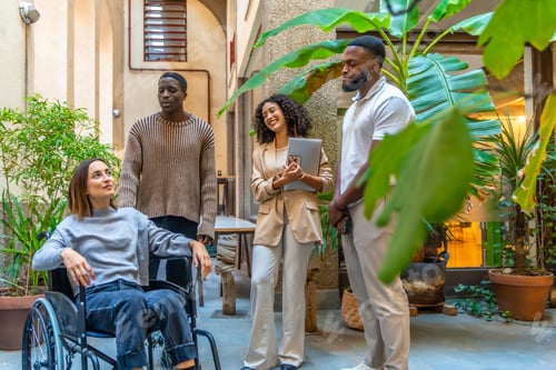 Preview: Disabled woman and coworking colleagues talking in a patio