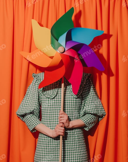 Preview: Style woman in green dress with pinwheel on orange curtains