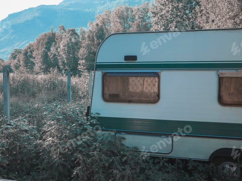 Preview: A vintage caravan parked amidst nature.