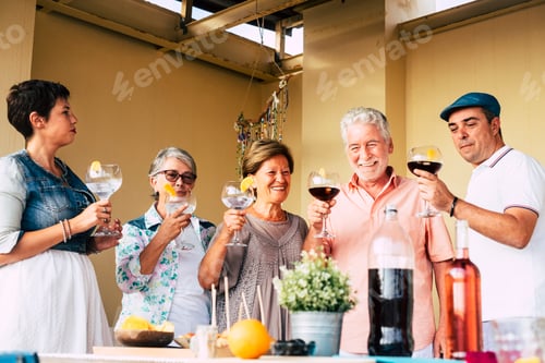 Preview: Group of mixed ages caucasian people enjoy together the lunch outdoor at home