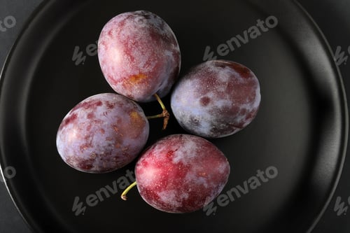 Preview: fresh plums in a black plate