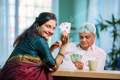 Preview: Mature Indian couple enjoying while playing cards together at home