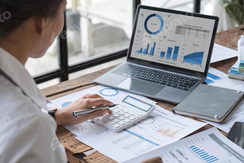 Preview: Business woman using calculator for do math finance on wooden desk in office and business working