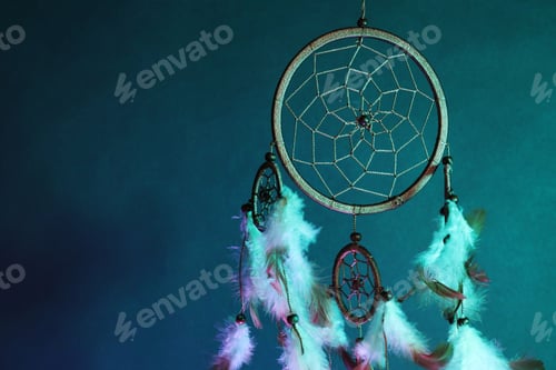 Preview: Beautiful dream catcher and smoke in color light on dark background, closeup. Space for text