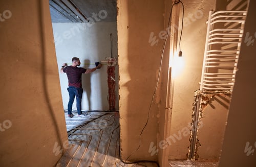 Preview: Professional technician measuring the wall in new apartment