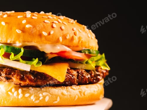 Preview: homemade grilled burger with meat patty, tomatoes, cucumber, lettuce, onion and sesame seeds.