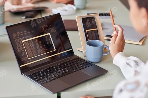 Preview: Close up of unrecognizable young woman using laptop with programming code