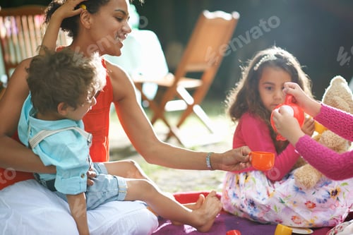 Preview: Mother and children playing picnics at garden birthday party