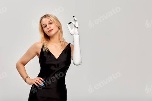 Preview: Studio portrait of beautiful young blonde girl with disability wearing sensory bionic prosthetic arm